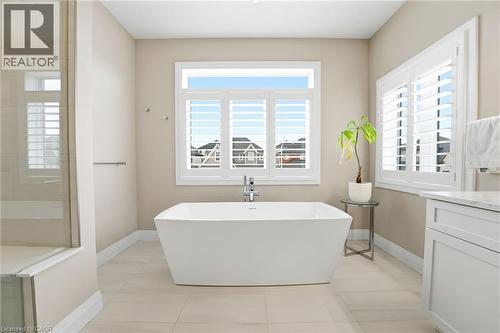 Full bath with vanity, a soaking tub, light tile patterned floors, and healthy amount of natural light - 39 Mill Race Crescent, St. Jacobs, ON - Indoor Photo Showing Bathroom