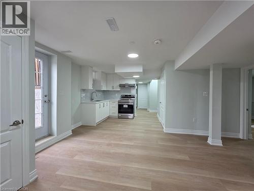Kitchen featuring light countertops, stainless steel range oven, tasteful backsplash, light wood-style flooring, and white cabinets - 367 Equestrian Way Unit# Basement, Cambridge, ON - Indoor