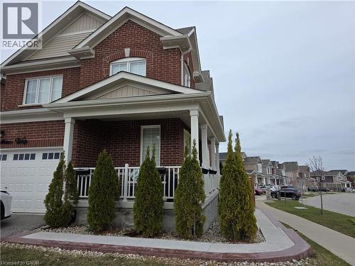 View of front facade featuring brick siding, a residential view, covered porch, a garage, and board and batten siding - 367 Equestrian Way Unit# Basement, Cambridge, ON - Outdoor