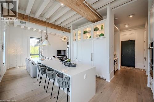 Kitchen featuring white cabinets, beam ceiling, glass insert cabinets, a kitchen breakfast bar, and a center island - 19 Guelph Avenue Unit# 308, Cambridge, ON - Indoor Photo Showing Kitchen