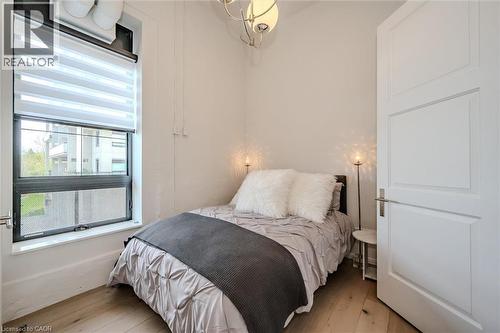 Bedroom with light wood-style flooring and suspended lighting - 19 Guelph Avenue Unit# 308, Cambridge, ON - Indoor Photo Showing Bathroom