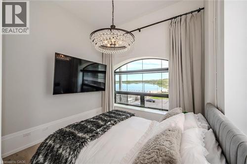 Bedroom featuring a chandelier and light wood finished floors - 19 Guelph Avenue Unit# 308, Cambridge, ON - Outdoor With Body Of Water With Balcony With View With Exterior