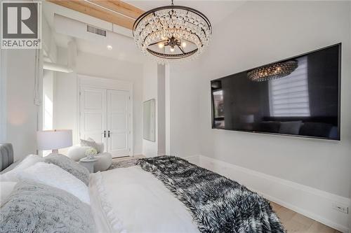 Bedroom featuring a chandelier and light wood-style flooring - 19 Guelph Avenue Unit# 308, Cambridge, ON - Indoor Photo Showing Bedroom