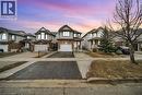 View of front of house with asphalt driveway, a garage, brick siding, and a residential view - 51 Seabrook Drive, Kitchener, ON  - Outdoor With Facade 