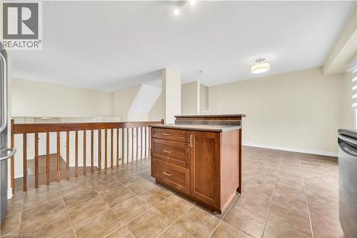 Kitchen with a kitchen island, wood finish cabinetry, stainless steel appliances, and light tile patterned floors - 51 Seabrook Drive, Kitchener, ON - Indoor Photo Showing Other Room