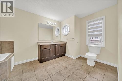 Bathroom with vanity, a garden tub, light tile patterned floors, and a textured ceiling - 51 Seabrook Drive, Kitchener, ON - Indoor Photo Showing Bathroom