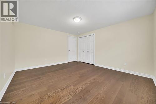Unfurnished bedroom featuring dark wood-style flooring and a closet - 51 Seabrook Drive, Kitchener, ON - Indoor Photo Showing Other Room