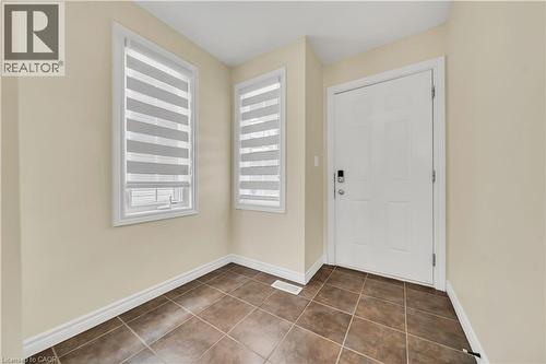 Foyer entrance featuring dark tile patterned floors and baseboards - 51 Seabrook Drive, Kitchener, ON - Indoor Photo Showing Other Room