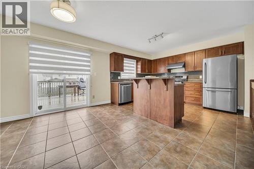 Kitchen with a kitchen breakfast bar, stainless steel appliances, light tile patterned floors, a kitchen island, and dark countertops - 51 Seabrook Drive, Kitchener, ON - Indoor Photo Showing Kitchen With Stainless Steel Kitchen