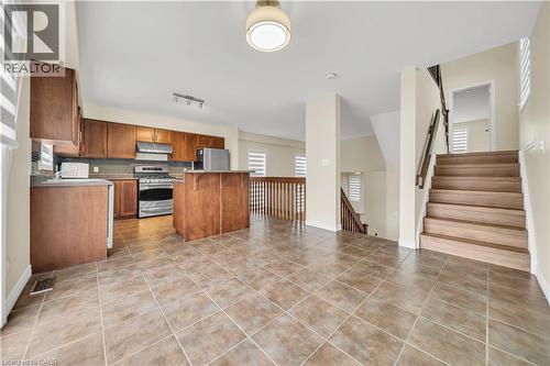 Kitchen with a center island, stainless steel appliances, light countertops, wood finish cabinets, and decorative backsplash - 51 Seabrook Drive, Kitchener, ON - Indoor Photo Showing Kitchen