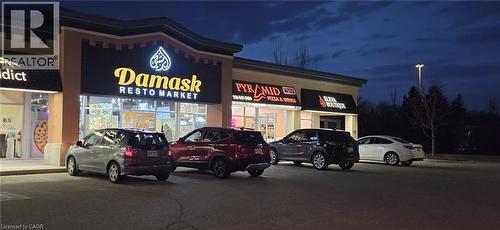 Property at twilight featuring view of commercial area and uncovered parking - 645 Westmount Road E Unit# 8, Kitchener, ON 