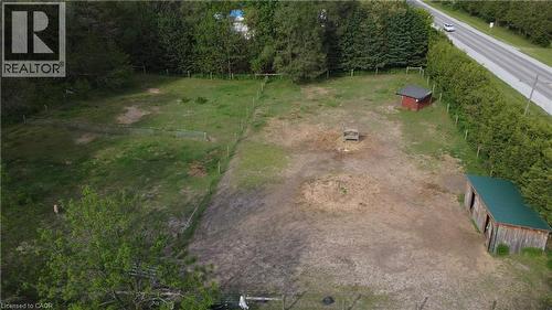 Expansive outdoor property featuring a wooden shed with a green roof, a red utility structure, and perimeter fencing - 535 Mcdowell Road E, Simcoe, ON 