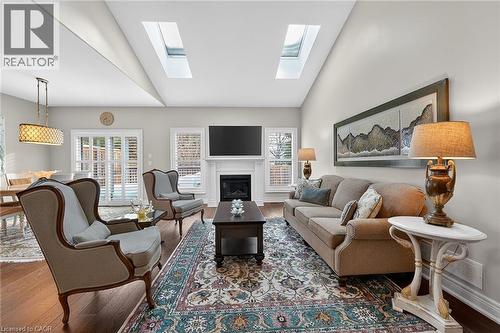 Sunlit living room with gas fireplace, vaulted ceilings and skylights - 1 Cedar Drive, St. Davids, ON - Indoor Photo Showing Living Room With Fireplace