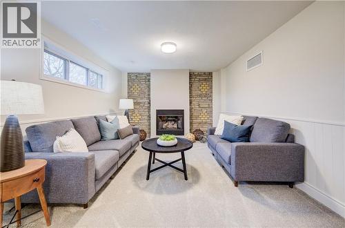 Orignal brickwork fireplace wall adds to the mid-century charm of this home. Cozy up next to the gas fireplace and relax with a good book. - 66 Tupper Crescent, Kitchener, ON - Indoor Photo Showing Living Room With Fireplace