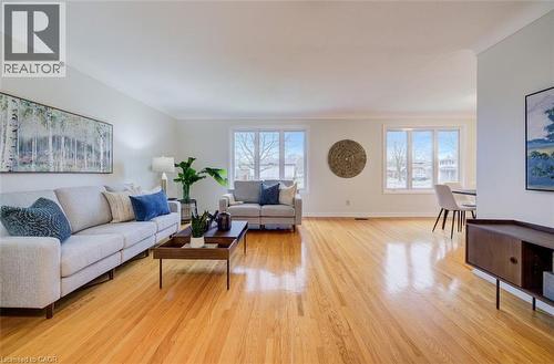 Main floor living room with gleaming, original hardwood flooring, bright windows and open to dining room - 66 Tupper Crescent, Kitchener, ON - Indoor Photo Showing Living Room
