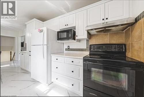 Kitchen with black appliances, light countertops, white cabinets, and decorative backsplash - 267 Erb Street E, Waterloo, ON - Indoor Photo Showing Kitchen