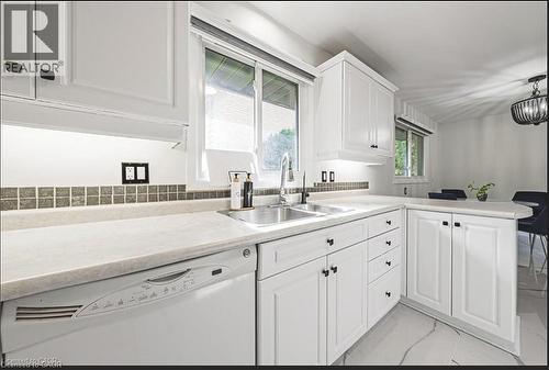 Kitchen featuring dishwasher, a peninsula, light countertops, white cabinetry, and light marble finish floors - 267 Erb Street E, Waterloo, ON - Indoor Photo Showing Kitchen