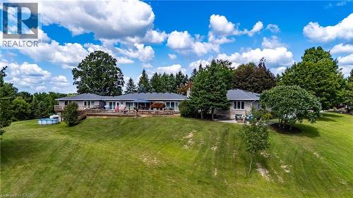 Rear view of property featuring a lawn and a wooden deck - 1285 Cockshutt Road, Simcoe, ON - Outdoor