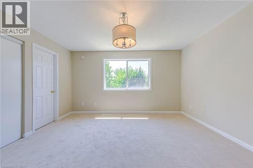 Primary bedroom featuring light carpet, a textured ceiling, and a closet - 3037 Abernathy Way, Oakville, ON - Indoor Photo Showing Other Room