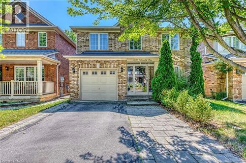 View of front of house with asphalt driveway, an attached garage, a porch, and brick siding - 3037 Abernathy Way, Oakville, ON - Outdoor