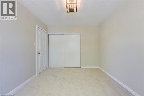Bedroom 4 with light carpet, a closet, and a textured ceiling - 3037 Abernathy Way, Oakville, ON - Indoor Photo Showing Other Room