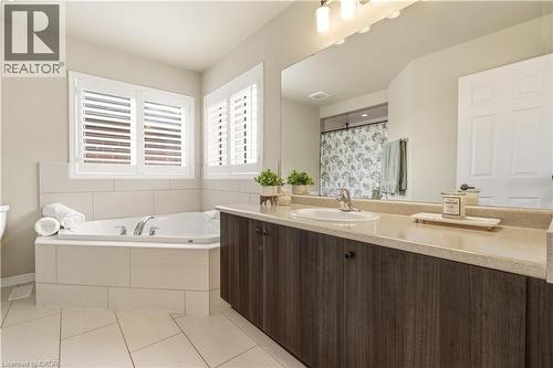 Full bath with a shower with curtain, vanity, a garden tub, and light tile patterned floors - 105 Larry Crescent, Caledonia, ON - Indoor Photo Showing Bathroom