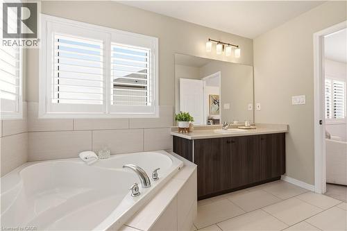 Full bathroom featuring a bath, vanity, and light tile patterned flooring - 105 Larry Crescent, Caledonia, ON - Indoor Photo Showing Bathroom