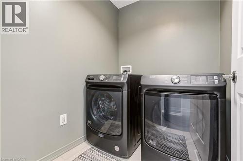 Laundry area with washing machine and clothes dryer and light tile patterned flooring - 105 Larry Crescent, Caledonia, ON - Indoor Photo Showing Laundry Room