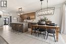 Kitchen with suspended lighting, a kitchen bar, a center island with sink, stainless steel appliances, and light tile patterned floors - 105 Larry Crescent, Caledonia, ON  - Indoor Photo Showing Dining Room 