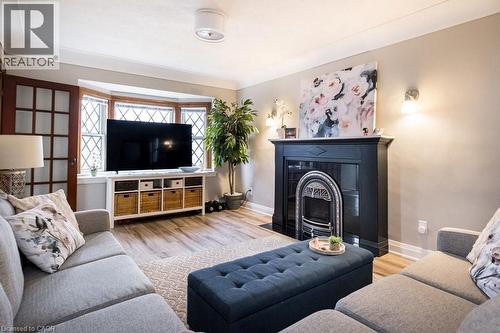 Living area with light wood-style flooring and a fireplace with flush hearth - 143 Huxley Avenue S, Hamilton, ON - Indoor Photo Showing Living Room