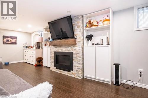 Living area with dark wood-style flooring and a fireplace - 143 Huxley Avenue S, Hamilton, ON - Indoor Photo Showing Living Room With Fireplace
