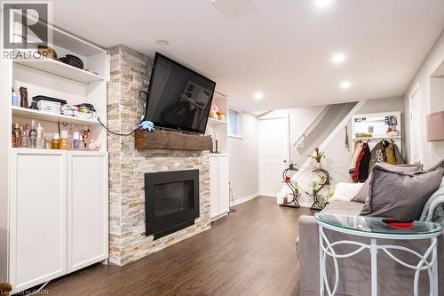 Living area with a fireplace, dark wood-type flooring, and recessed lighting - 143 Huxley Avenue S, Hamilton, ON - Indoor Photo Showing Living Room With Fireplace