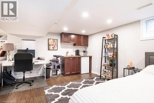 Bedroom featuring dark wood-style floors, white refrigerator, a desk, and recessed lighting - 143 Huxley Avenue S, Hamilton, ON - Indoor