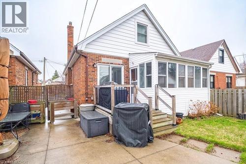 Back of house with a sunroom, a chimney, and brick siding - 143 Huxley Avenue S, Hamilton, ON - Outdoor With Deck Patio Veranda