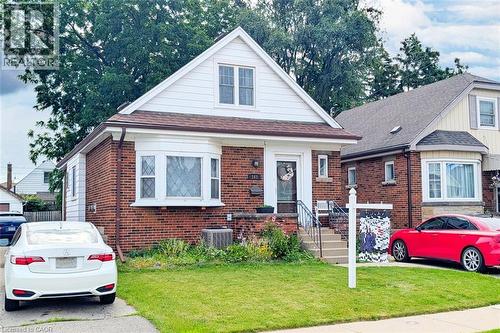 Brick exterior with white siding accents and a pitched roof - 143 Huxley Avenue S, Hamilton, ON - Outdoor