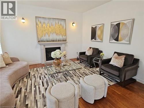 Living area featuring hardwood flooring, a fireplace with a detailed mantelpiece, and neutral wall tones - 512 Wood Nettle Way, Waterloo, ON - Indoor Photo Showing Living Room With Fireplace