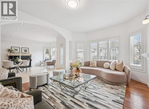 Bright living area featuring a bay window with plantation shutters, recessed lighting, and wood-finish flooring - 512 Wood Nettle Way, Waterloo, ON - Indoor Photo Showing Living Room