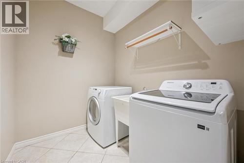 Laundry room with washing machine and clothes dryer and light tile patterned floors - 512 Wood Nettle Way, Waterloo, ON - Indoor Photo Showing Laundry Room