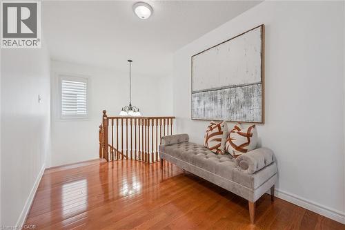 Sitting room with hardwood / wood-style flooring, an upstairs landing, and suspended lighting - 512 Wood Nettle Way, Waterloo, ON - Indoor Photo Showing Other Room