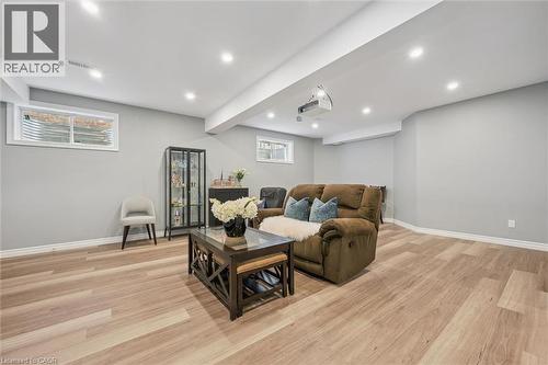 Living room featuring light wood-style floors, recessed lighting, healthy amount of natural light, and beam ceiling - 512 Wood Nettle Way, Waterloo, ON - Indoor Photo Showing Basement