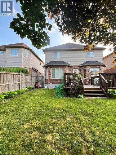Back of property with a wooden deck, a fenced backyard, and brick siding - 512 Wood Nettle Way, Waterloo, ON - Outdoor With Deck Patio Veranda