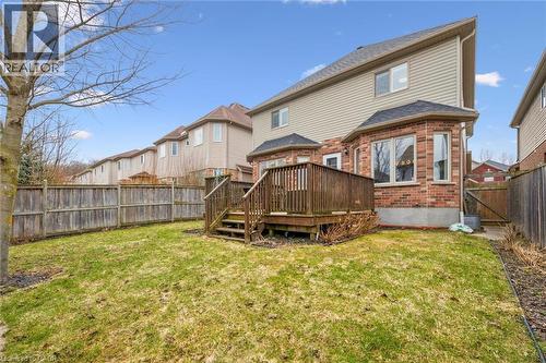 Back of property with a fenced backyard, a wooden deck, brick siding, a gate, and a residential view - 512 Wood Nettle Way, Waterloo, ON - Outdoor