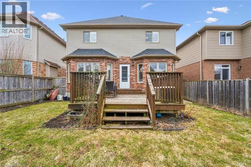 Rear view of property with a fenced backyard, a deck, brick siding, and roof with shingles - 512 Wood Nettle Way, Waterloo, ON - Outdoor