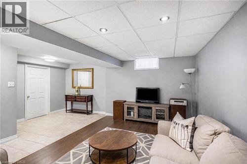 Living area with a paneled ceiling and wood finished floors - 65 Thistlemoor Drive, Caledonia, ON - Indoor Photo Showing Basement