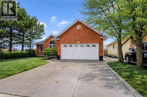 View of front of home featuring brick siding, a front yard, concrete driveway, and a garage - 65 Thistlemoor Drive, Caledonia, ON - Outdoor