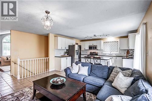 Living room with a textured ceiling, suspended lighting, and light tile patterned flooring - 65 Thistlemoor Drive, Caledonia, ON - Indoor Photo Showing Living Room