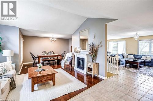 Tiled living room with hanging lights, a glass covered fireplace, and vaulted ceiling - 65 Thistlemoor Drive, Caledonia, ON - Indoor Photo Showing Living Room With Fireplace