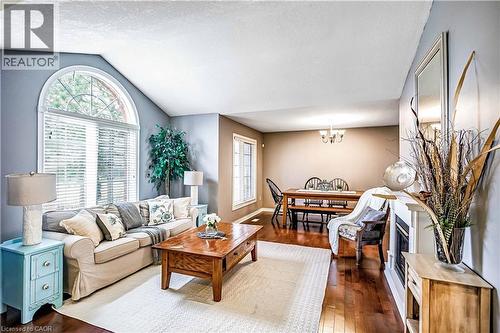 Living area featuring dark wood-style floors and a chandelier - 65 Thistlemoor Drive, Caledonia, ON - Indoor Photo Showing Living Room