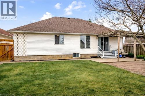 Rear view of house featuring entry steps, a patio, and a shingled roof - 65 Thistlemoor Drive, Caledonia, ON - Outdoor