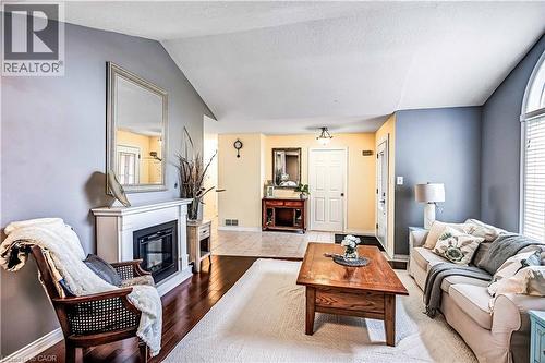 Living room with a glass covered fireplace and light wood-type flooring - 65 Thistlemoor Drive, Caledonia, ON - Indoor Photo Showing Living Room With Fireplace